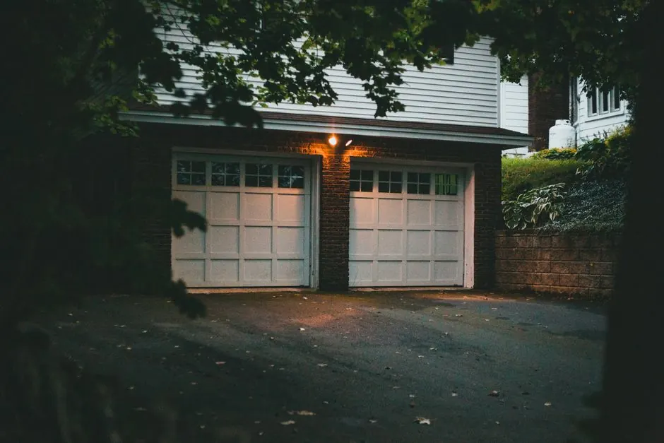 Warm evening view of a suburban garage with soft lighting creating a cozy atmosphere.